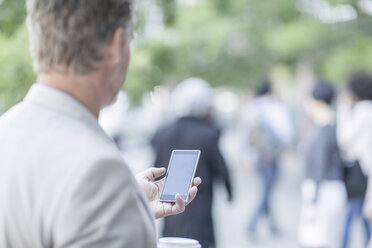 Älterer Mann auf der Straße mit Mobiltelefon - ZEF007766