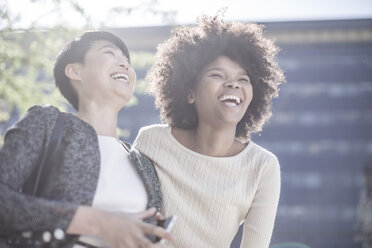 Two young woman laughing in the city - ZEF007770