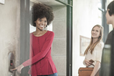 Young woman waiting for colleagues at the elevator - ZEF007799