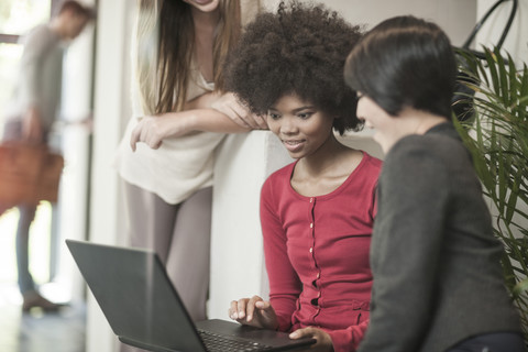 Junge Frauen schauen auf einen Laptop, lizenzfreies Stockfoto