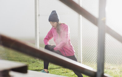 Junge Frau beim Workout auf einem Sportplatz - UUF006262