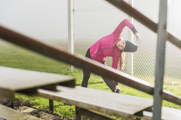 Junge Frau beim Workout auf einem Sportplatz - UUF006263