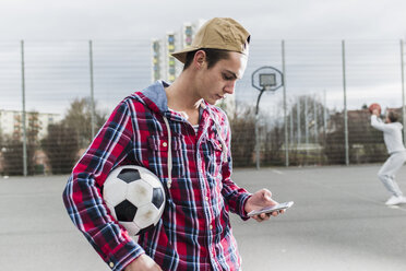 Junger Fußballspieler mit Smartphone - UUF006300