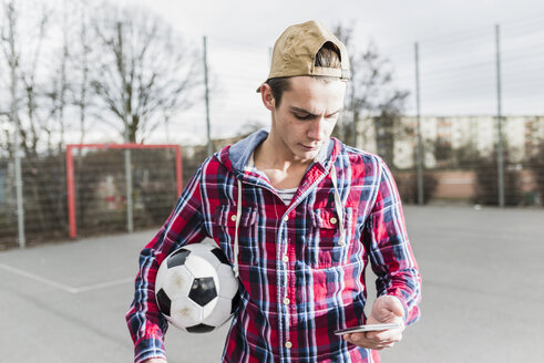 Junger Fußballspieler mit Smartphone - UUF006301