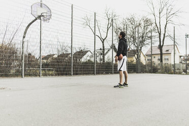 Young basketball player in front of basketball hoop - UUF006310