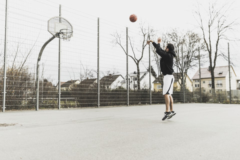Junger Mann spielt Basketball, lizenzfreies Stockfoto