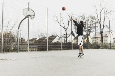 Junger Mann spielt Basketball - UUF006311