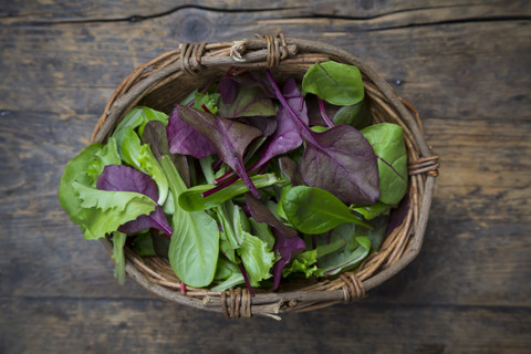 Weidenkorb mit verschiedenen Bio-Salatblättern, lizenzfreies Stockfoto