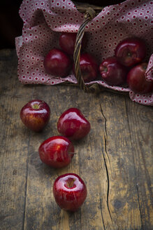 Vier rote Äpfel auf dunklem Holz - LVF004371