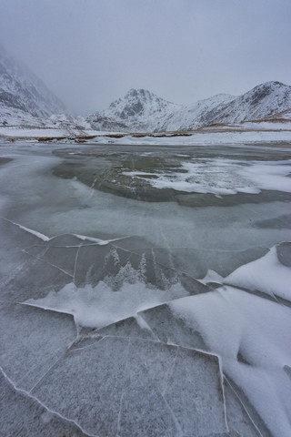 Norwegen, Lofoten, zugefrorener See im Winter, lizenzfreies Stockfoto