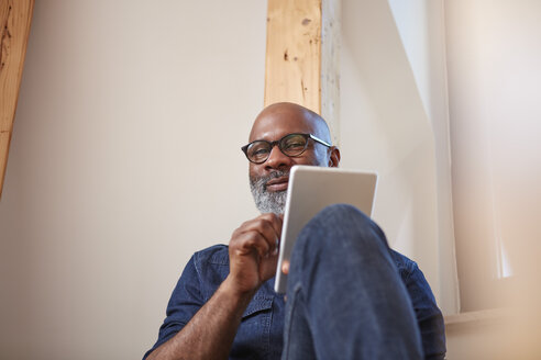 Portrait of smiling man with digital tablet - RHF001151