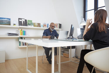 Zwei Menschen arbeiten am Schreibtisch in einem Büro - RHF001169