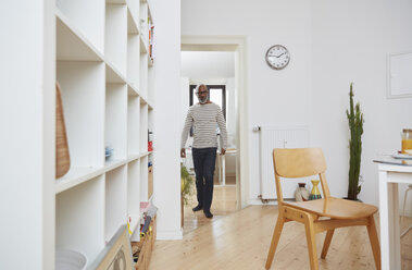 Man carrying his laptop in the kitchen - RHF001172