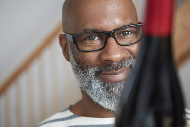 Portrait of smiling man with wine bottle - RHF001209