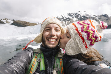 Peru, couple wearing wool chullos and kissing - GEMF000584