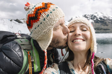 Peru, couple wearing wool chullos and kissing - GEMF000585