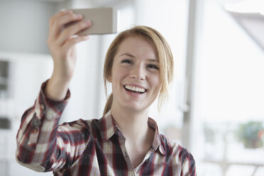 Portrait of smiling young woman taking a selfie with her smartphone - RBF003839