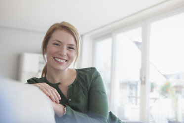 Portrait of smiling young woman on the couch at home - RBF003873