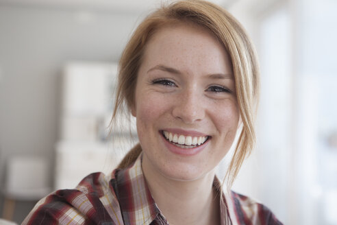 Porträt einer glücklichen jungen Frau mit Sommersprossen - RBF003889