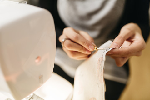 Junge Modedesignerin bei der Arbeit in ihrem Atelier, lizenzfreies Stockfoto