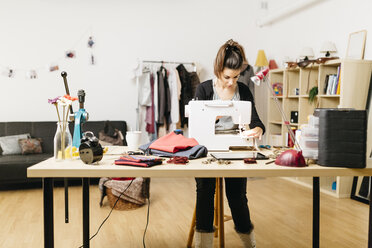 Junge Modedesignerin bei der Arbeit in ihrem Atelier - JRFF000266