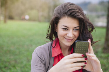 Porträt eines lächelnden jungen Mannes mit Smartphone - ALBF000015