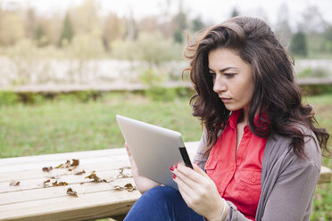 Young woman using digital tablet in a park - ALBF000016