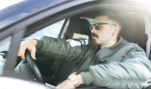 Junger Mann am Steuer eines Autos, lizenzfreies Stockfoto