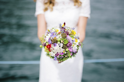 Die Braut hält ihren Blumenstrauß, lizenzfreies Stockfoto