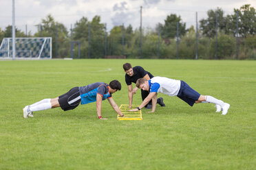 Trainer beim Training mit Fußballspielern auf dem Sportplatz - SHKF000389