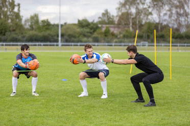 Trainer beim Training mit Fußballspielern auf dem Sportplatz - SHKF000396