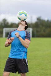 Fußballspieler balanciert Ball auf dem Kopf - SHKF000398