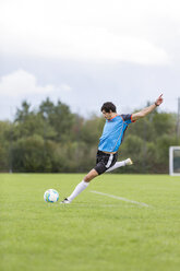 Soccer player kicking ball on sports field - SHKF000399