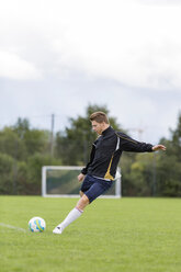 Soccer player kicking ball on sports field - SHKF000400