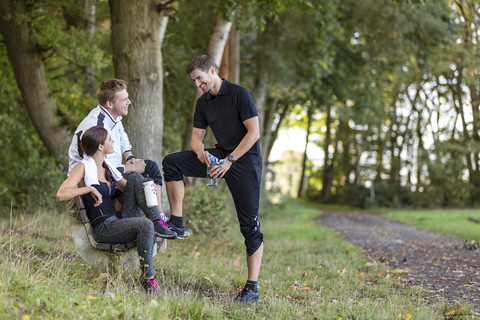 Athletes resting on a park bench stock photo