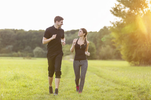 Man and woman jogging in field stock photo