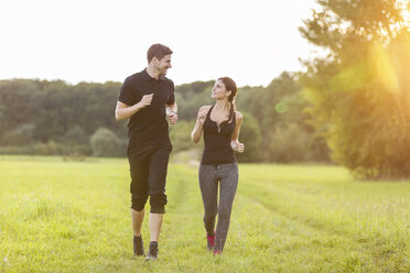 Man and woman jogging in field - SHKF000408