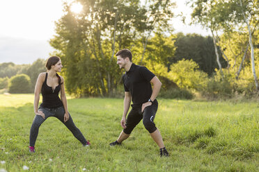 Man and woman stretching in field - SHKF000412