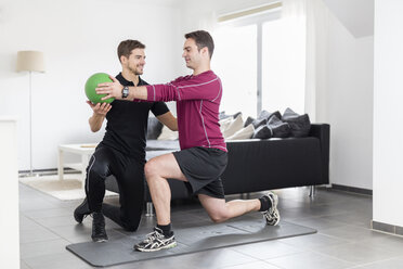 Trainer macht Übungen mit Mann zu Hause - SHKF000424