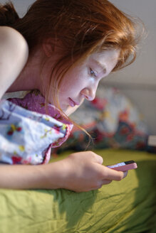 Profil eines Mädchens im Bett mit Smartphone - LBF001336