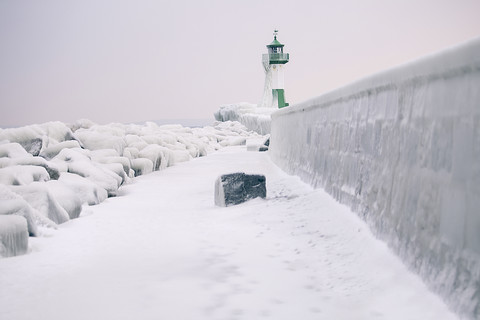 Deutschland, Mecklenburg-Vorpommern, Rügen, Sassnitz, Hafen mit Leuchtturm im Winter, lizenzfreies Stockfoto