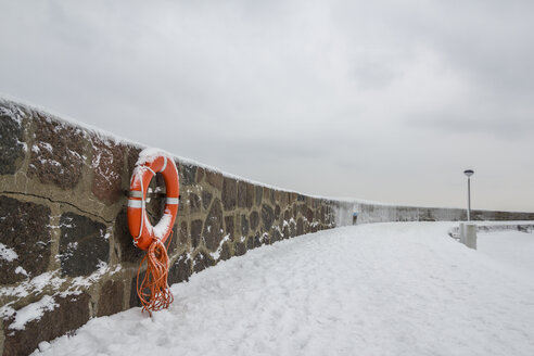 Germany, Sassnitz, life belt on wall in winter - ASCF000442