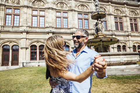 Austria, Vienna, smiling couple dancing Viennese waltz in front of state opera stock photo
