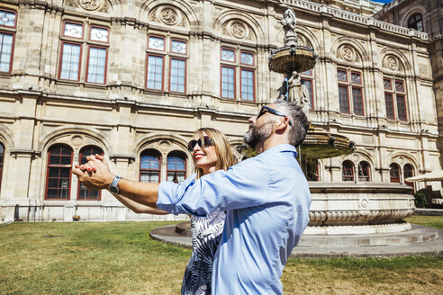 Österreich, Wien, lächelndes Paar tanzt Wiener Walzer vor der Staatsoper - AIF000167