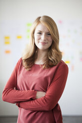 Young woman in office with arms crossed - RBF003914