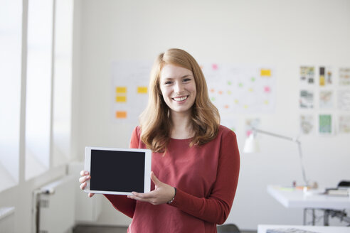 Junge Frau im Büro mit digitalem Tablet - RBF003918