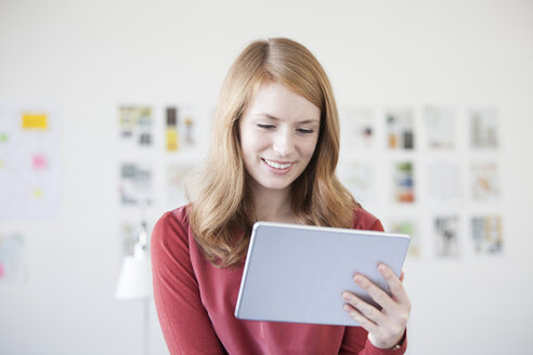 Junge Frau im Büro mit digitalem Tablet - RBF003919