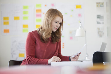 Young woman in office, working at desk - RBF003921