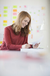 Young woman in office, working at desk - RBF003923