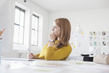 Junge Frau im Büro bei der Arbeit am Schreibtisch - RBF003942